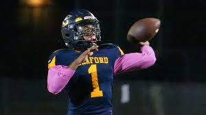 Seaford football player preparing to throw a pass under the lights.