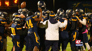 Seaford football players celebrating together at night.